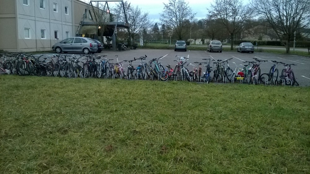 CARNETS INSITUÉS: Suspended Spaces_ 0.2 | Ce carnet s'inscrit dans une série de récits récoltés et soulevés en images sur des sites vacants réinvestis et occupés de manière autonome ou informelle.
Ce travail est initié par Cynthia Montier.
Ce carnet reprend sous la forme de micro-publications l'idée de cartes postales, de mémoire vagabonde en circulation instantanée dans un premier temps via la plateforme Archipel, puis transitée sur Instagram; Elle sera imprimée et éditée dans un deuxième temps sous la forme de petites éditions nomades et volatiles à faire voyager, mais cette fois-ci à partir d’objets photographiés en fragments et choisis par les habitants de la zone occupée.
Anthropologie d’un voyage, intervention sur le site de l’Hôtel Formule 1 dans la commune d’Ennery (57), là où la mairesse mobilise l’établissement pour accueillir des réfugiés Syriens.
&quot;Situation relevée lors d’une promenade opportune dans la commune d’Ennery, je tombe sur l’hôtel F1 avoisinant son iconique rond point au carrefour de la zone industrielle Eurotransit. L’hôtel Formule 1 d’Ennery est depuis longtemps le repaire des travailleurs routiers qui transitent en séjours le temps d’une livraison aux entreprises locales.
Cette fois-ci, le parking du F1 n’abrite aucun poids-lourd ni véhicule utilitaire.
A la place : des tentes, des campements, des abris. Par les fenêtres : des linges, des vêtements, des draps. A l'arrière de l'édifice : des lignes de vélos les uns sur les autres. Devant l'entrée : des chaises, des tables, des dispositions de rassemblements suspendus. Dans les carrés d’herbes et pelouses jardinées, de véritables playgrounds, aires de jeux et espaces de loisirs se sont improvisés; La zone Eurotransit prend des allures de zone autonome temporaire.
La fonction primaire de ce lieu en transit nous renvoie inévitablement à l’évocation d’un voyage, d’un exil, d'une forme de tourisme ou de voyage professionnel, ce voyage est cette fois-ci contraint. Le mouvement qui rassemble ses résidents déplacés semble avoir été insufflé par un vent, par une vague, aménageant tout autour d'elle un terrain en résistance, un espoir au sol.&quot;