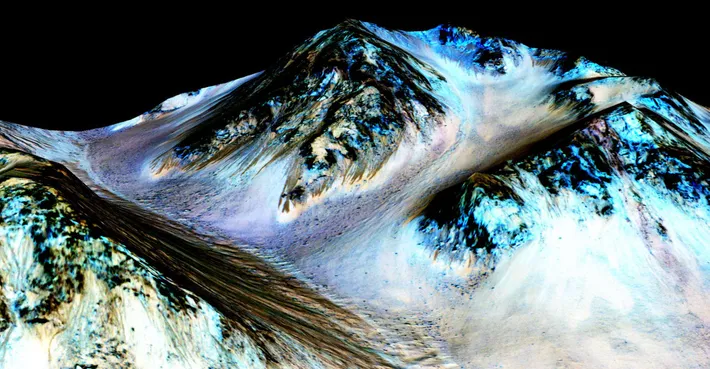 Cratère Hale sur Mars | À l'intérieur du cratère martien Hale, des traces sombres (brunes) longues de 100 mètres ont été formées par des écoulements d'eau salée liquide. Elles apparaissent pendant les saisons chaudes, puis disparaissent rapidement.