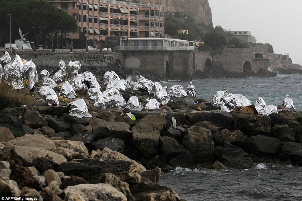 Fifty Refugees by the sea huddle | Reuters photographer, Fifty Refugees by the sea huddle